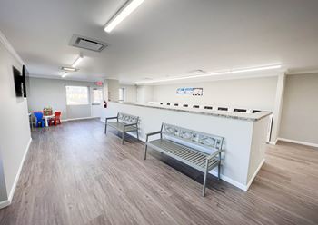 An empty waiting room with benches and a counter